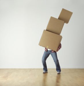 A person carrying three large boxes