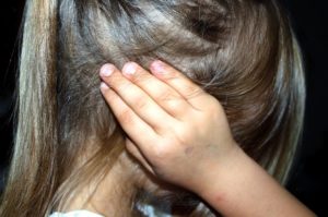 A child covering her ears. 